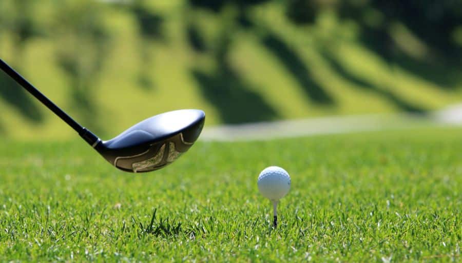 a golfer about to tee off on a green