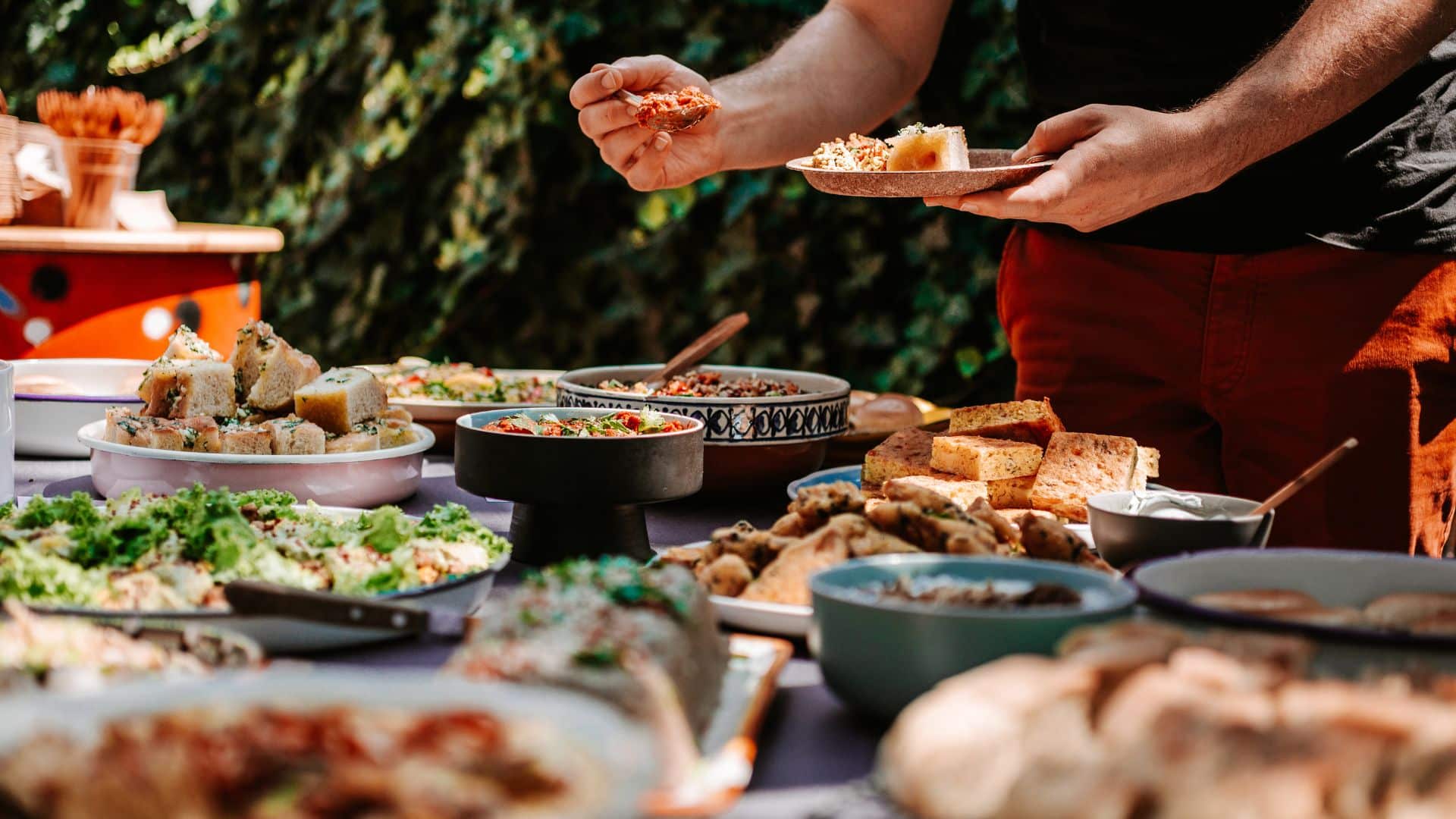 a person is serving themselves food from a large table outside