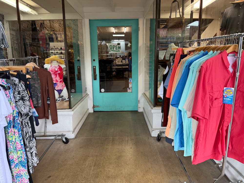A clothing store in Calistoga-town featuring racks of clothes and a welcoming entrance door.