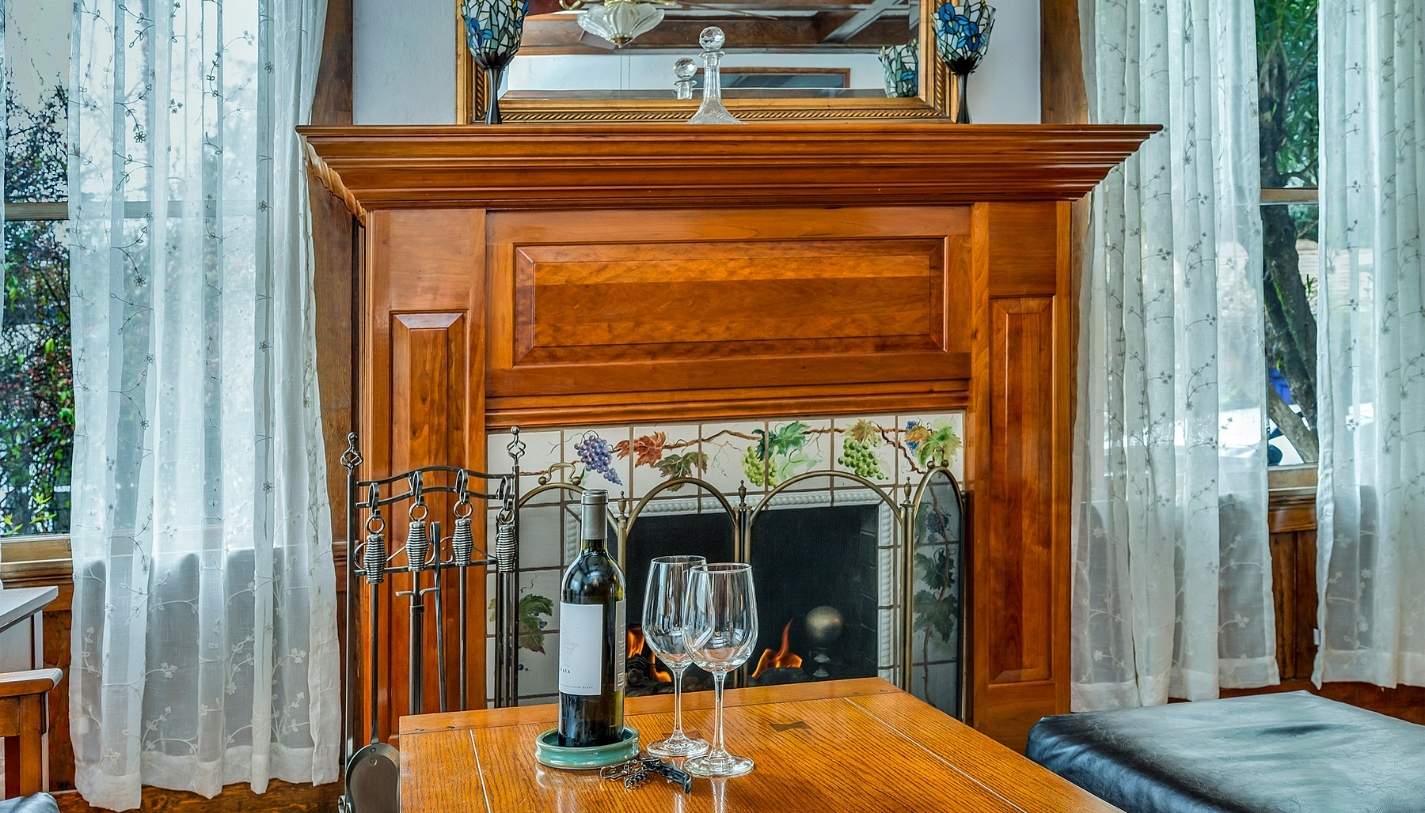 Wine and wine glasses in front of fireplace at Wine Way Inn in Calistoga