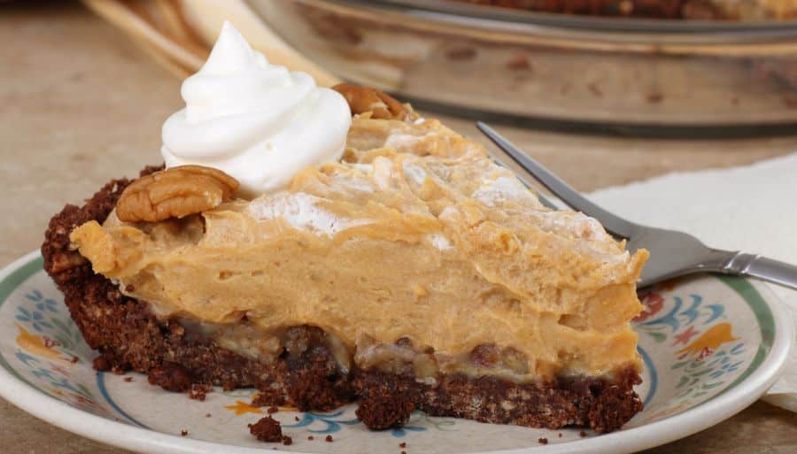 Slice of peanut butter pie with a dollop of whipped cream