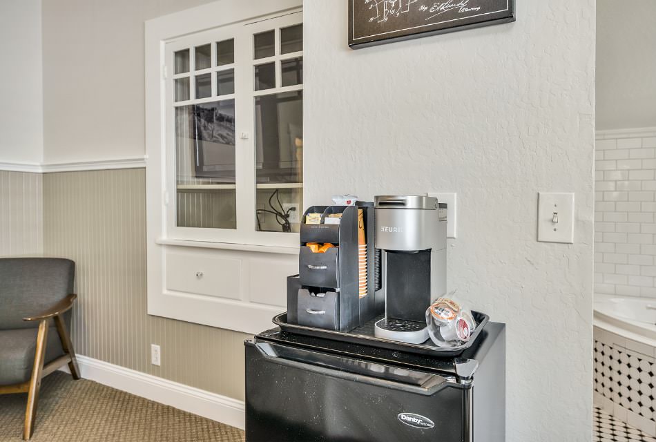 Keurig coffee maker and bag of Keurig pods on top of black mini fridge