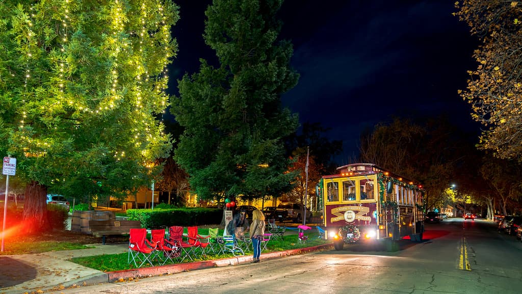 The Napa Valley Wine Trolley driving through Calistoga during the Calistoga Lighted Tractor Parade