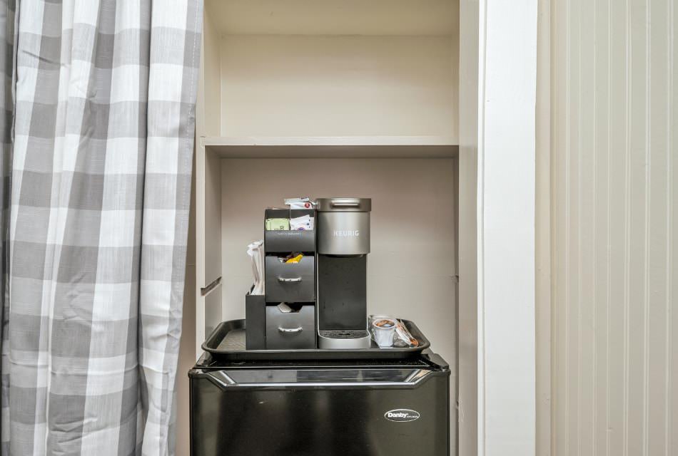 Keurig coffee maker on top of black mini fridge