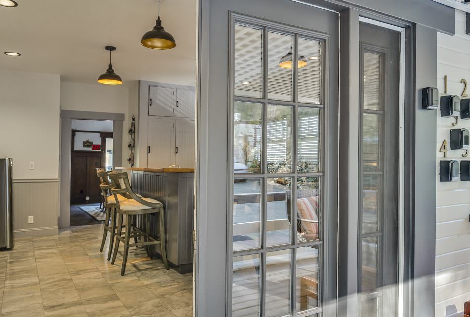 Close up of gray exterior front door opened to see the inside of the kitchen