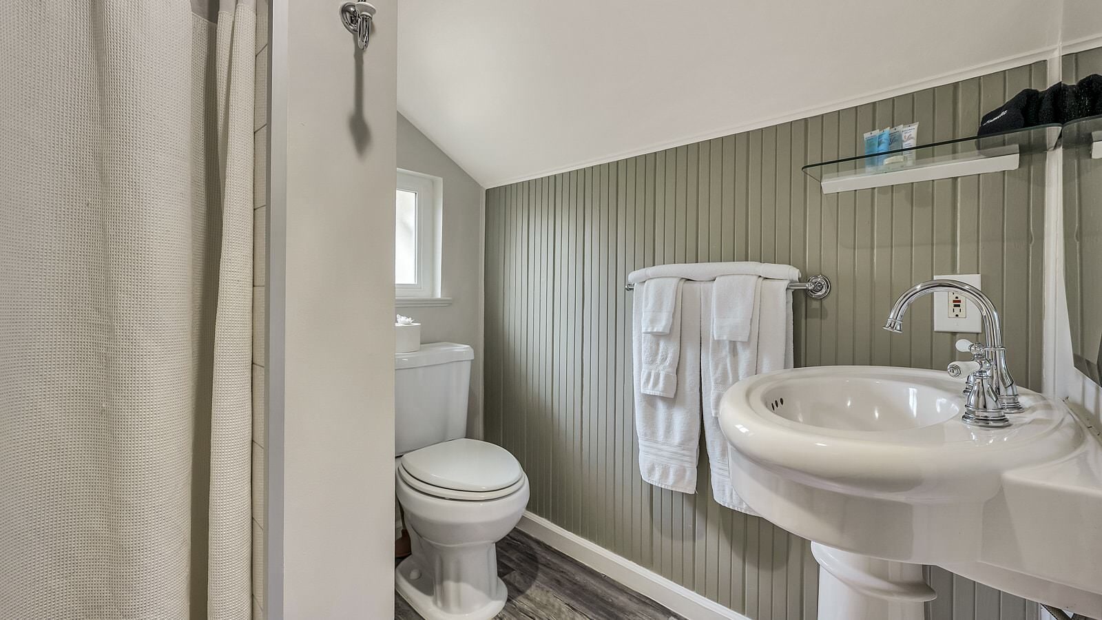 Bathroom with gray and white walls, stand up shower, white toilet, and white sink