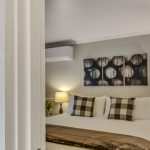 View into bedroom with gray walls, white bedding, and dark wooden nightstands