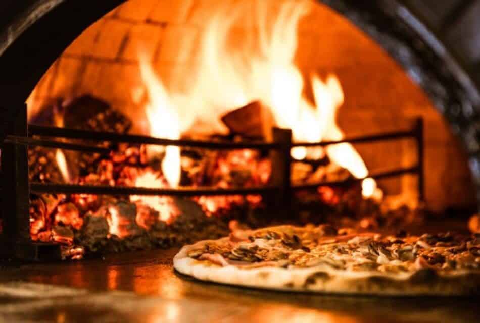 Close up view of pizza by wood fire oven