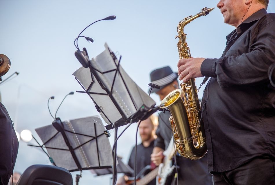 A man in an orchestra playing the saxophone