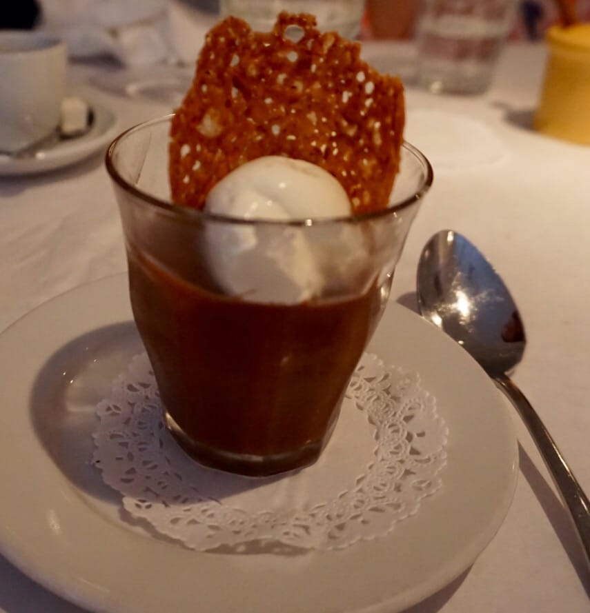 Chocolate pot de creme with cream and brittle on white table cloth at Bistro Jeanty Restaurant in Yountvulle, CA, in the Napa Valley Wine Country; fine dining