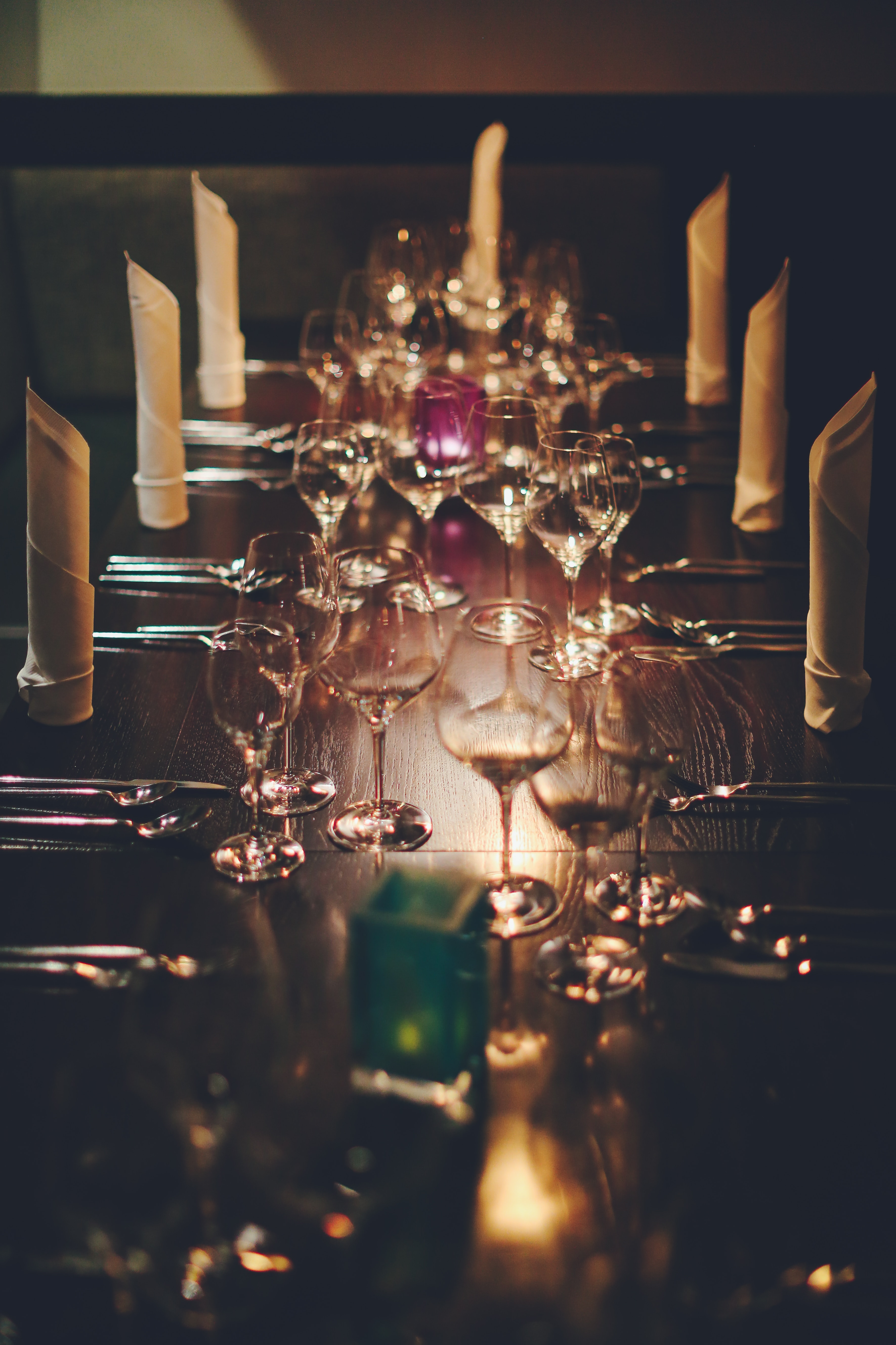 A exquisite table setting with carefully folded napkins and rows of wine glasses.