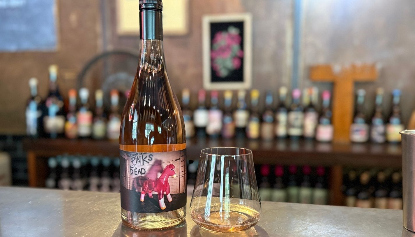 A bottle of wine and wine glass on the bar at the Tank winery tasting room in Calistoga